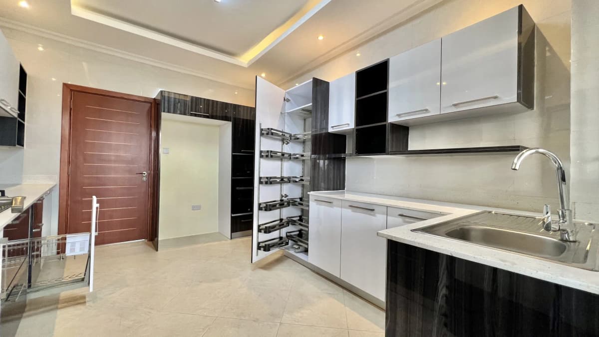 Modern kitchen with white cabinets, black island, stainless sink