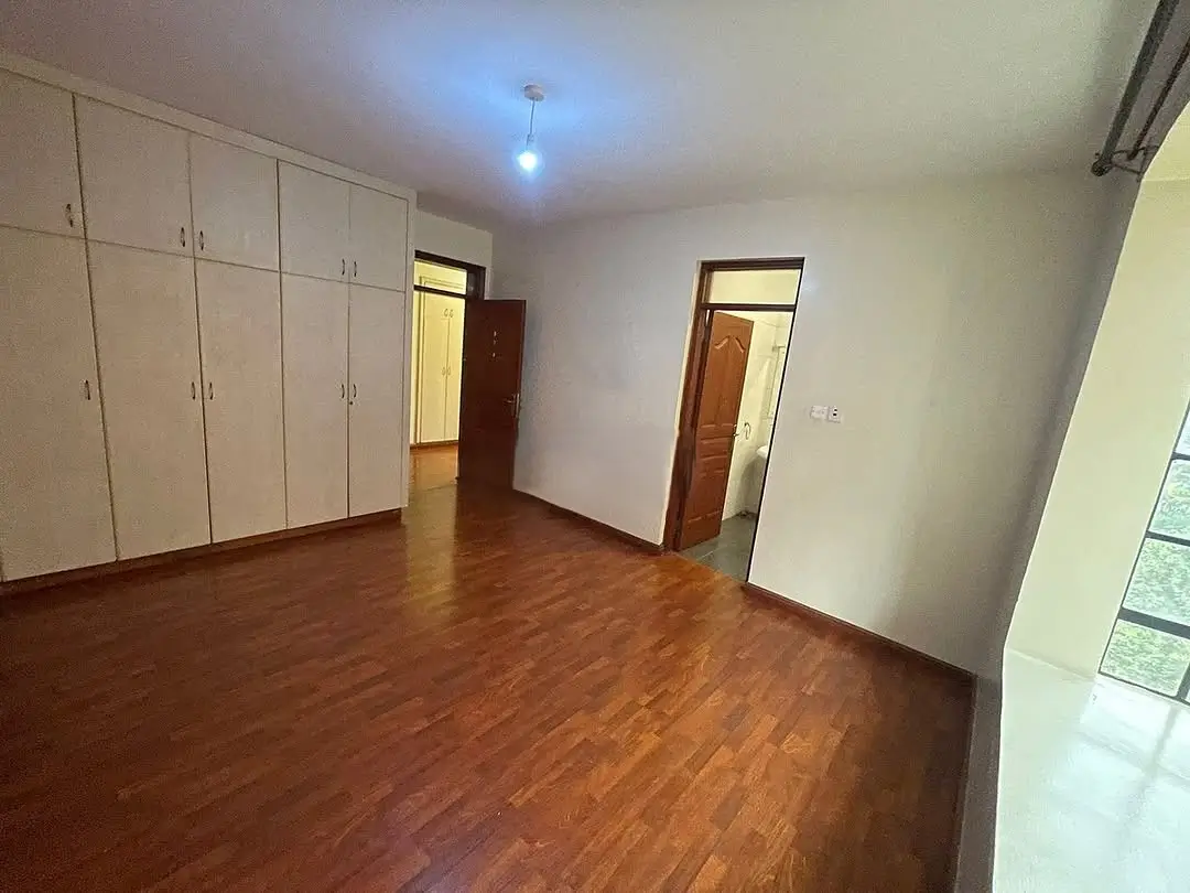 Spacious bedroom with built-in wardrobes and wooden flooring