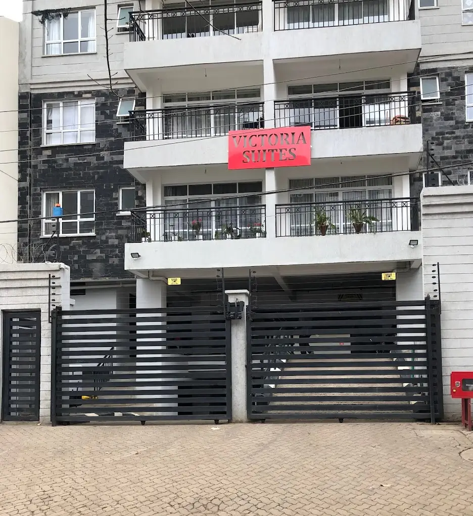 Modern multi-story apartment building with black metal gates and balconies
