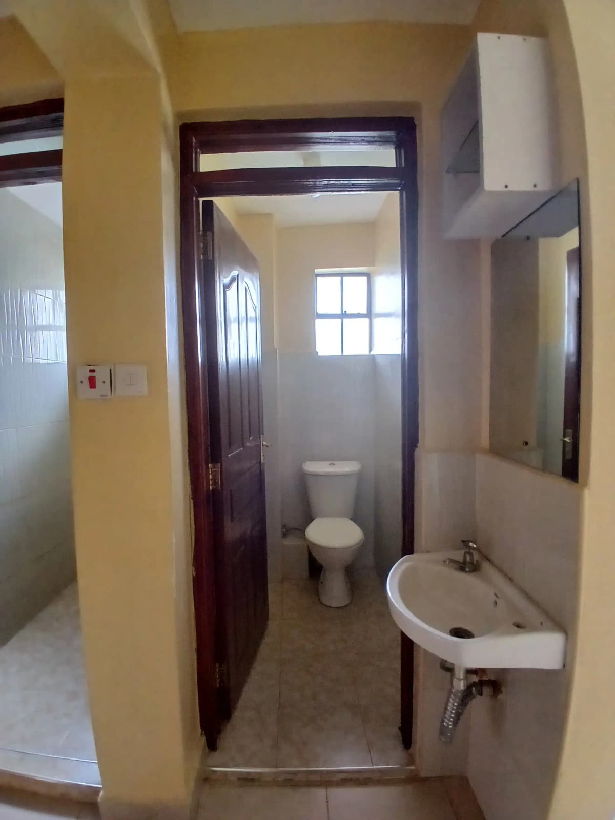 Compact bathroom with toilet, sink, and small window