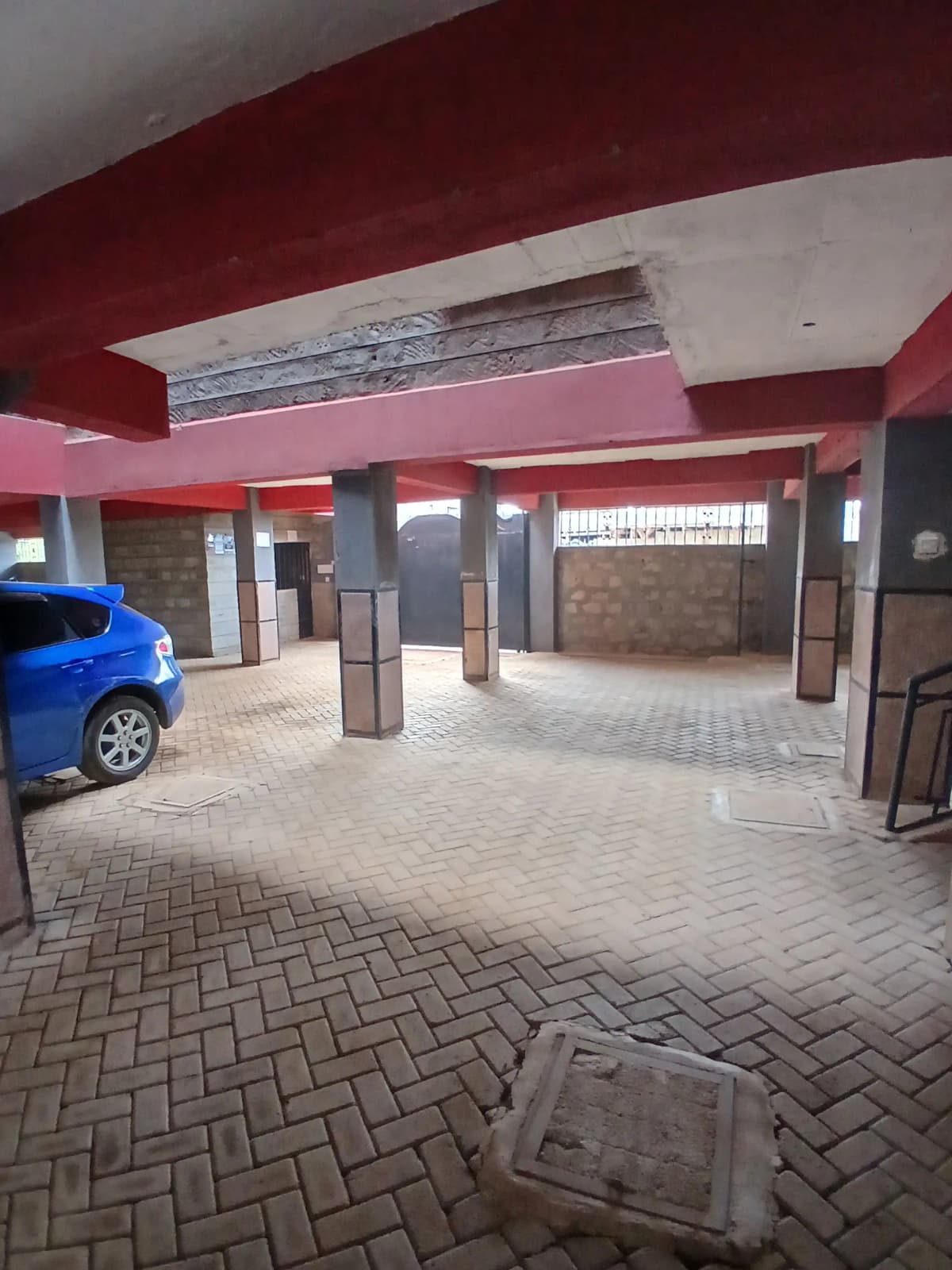Covered basement parking with herringbone tiles and support pillars