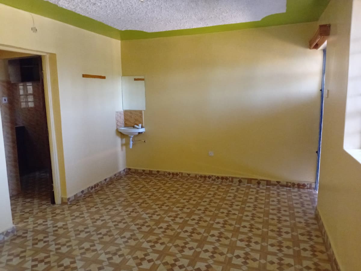 Empty bedroom with green accent wall and tiled floor
