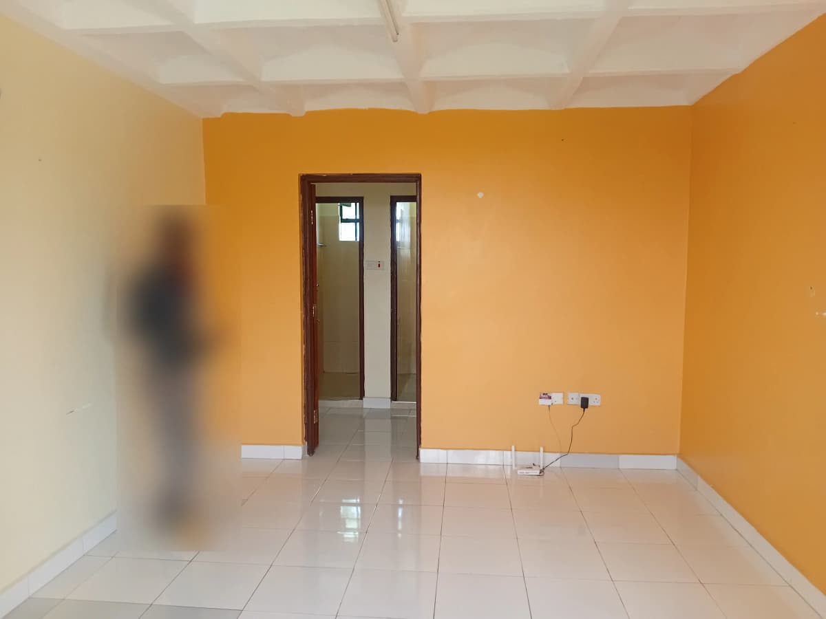 Empty living room with orange walls and polished tile flooring