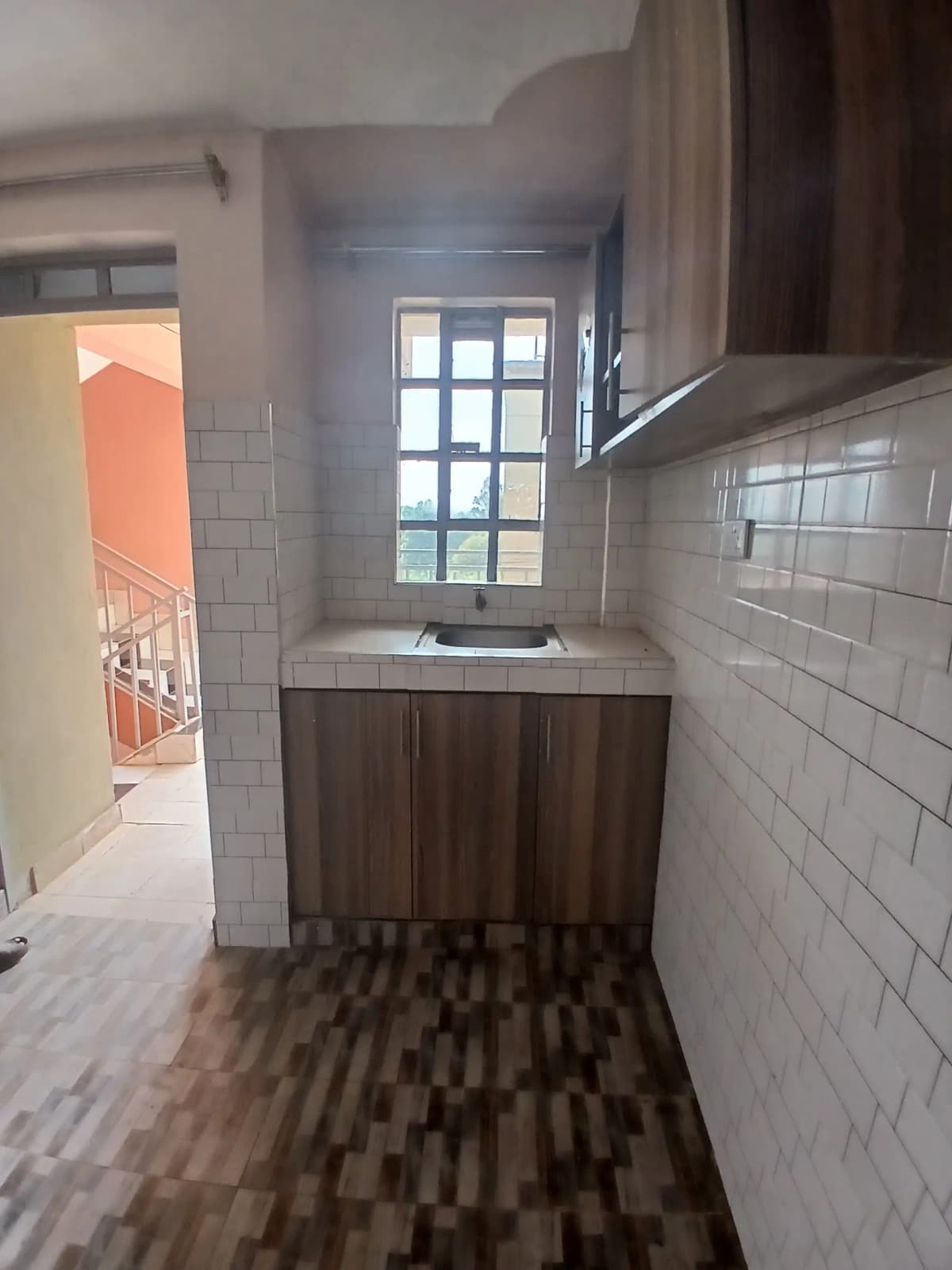 Modern galley kitchen with dark cabinetry and subway tile