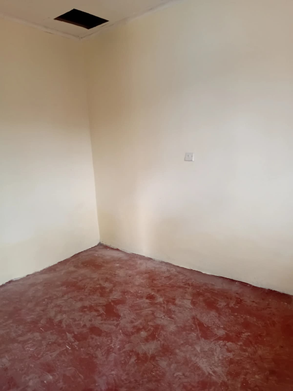 Empty bedroom with burgundy carpet and ceiling vent