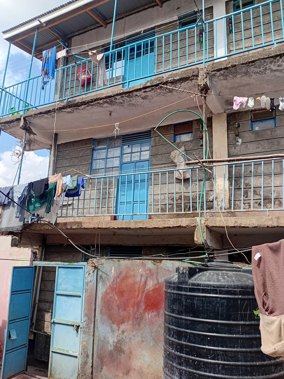 Multi-story residential building facade with blue railings