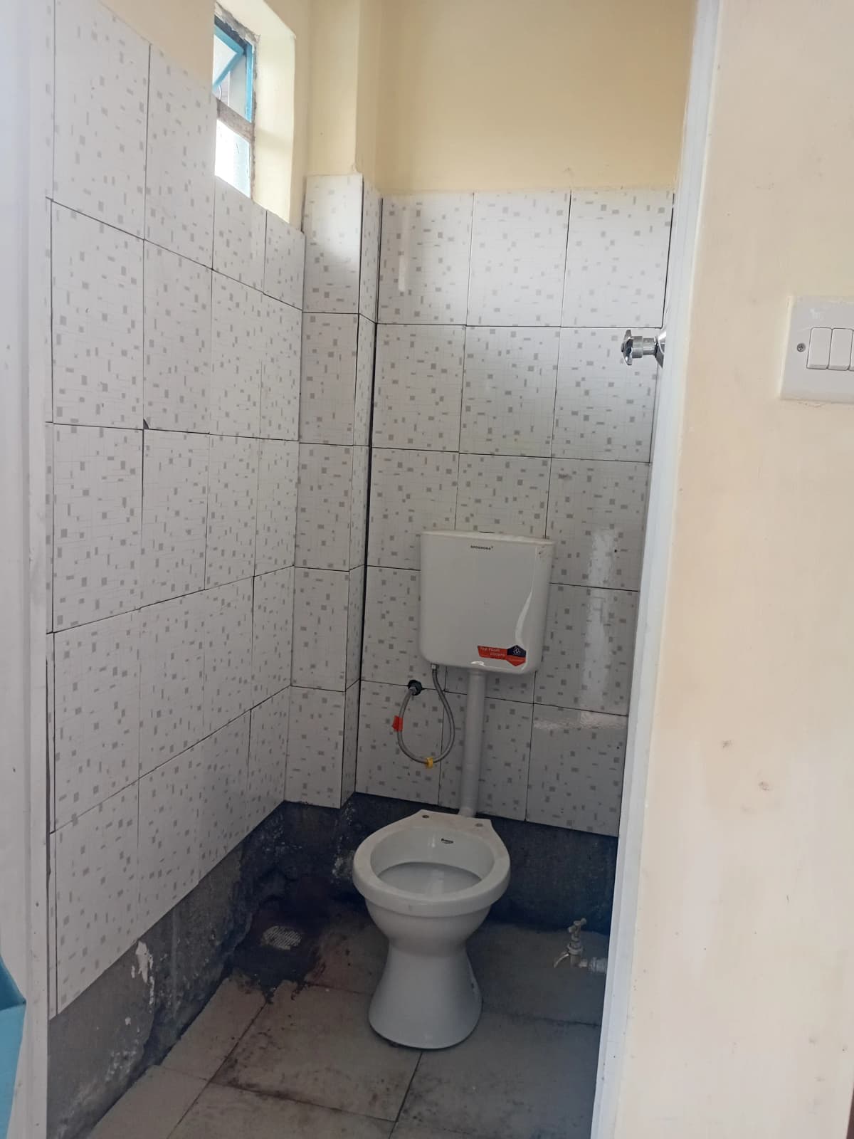 Compact bathroom with white tile walls and ceramic toilet