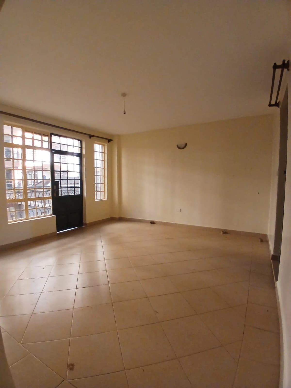 Spacious living room with ceramic tile flooring and natural light