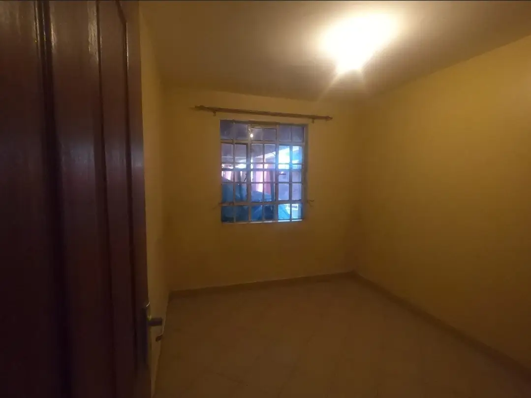 Bright yellow bedroom with window and dark wood door