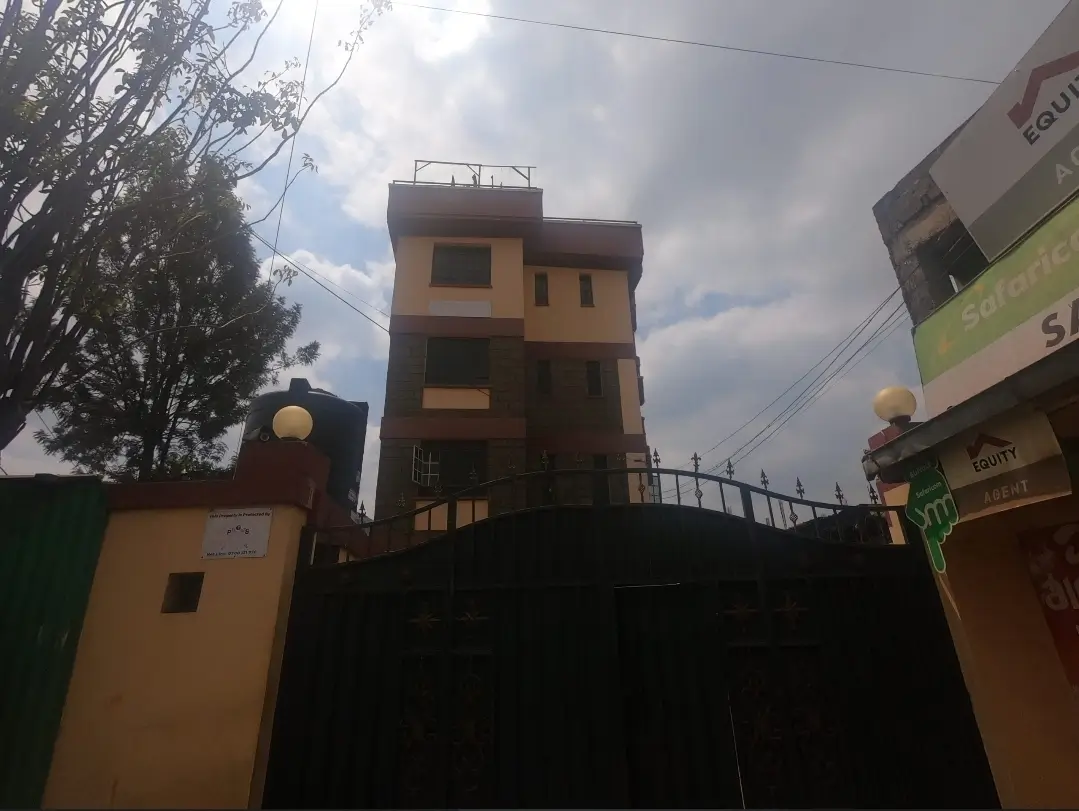 Multi-story residential building facade with compound gate