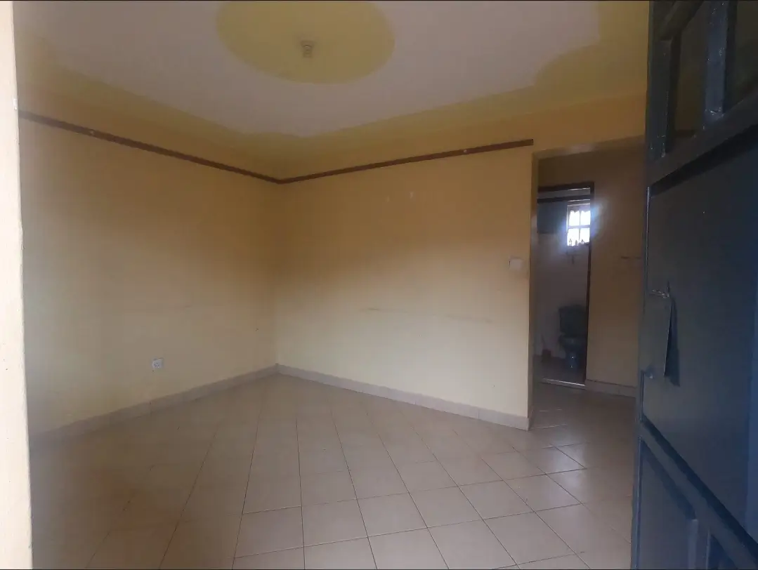 Empty living room with tiled flooring and cream walls