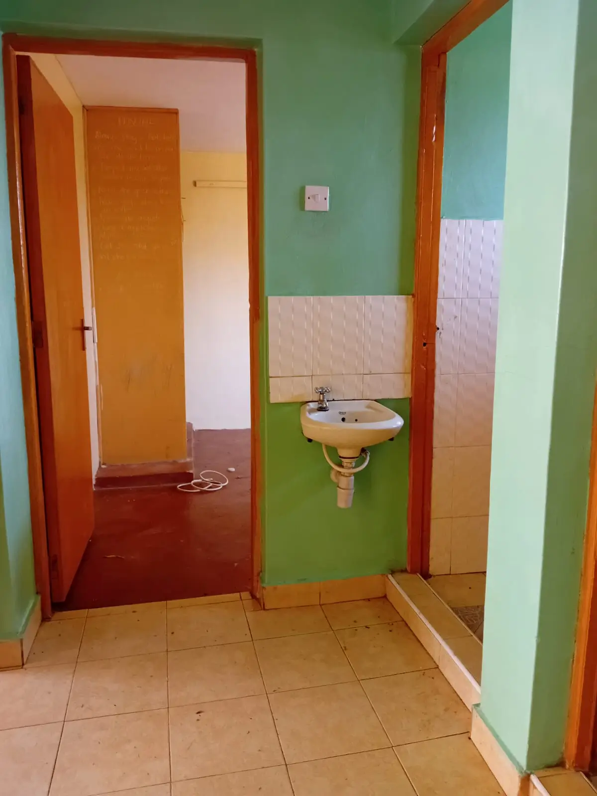 Compact bathroom with pedestal sink and green walls