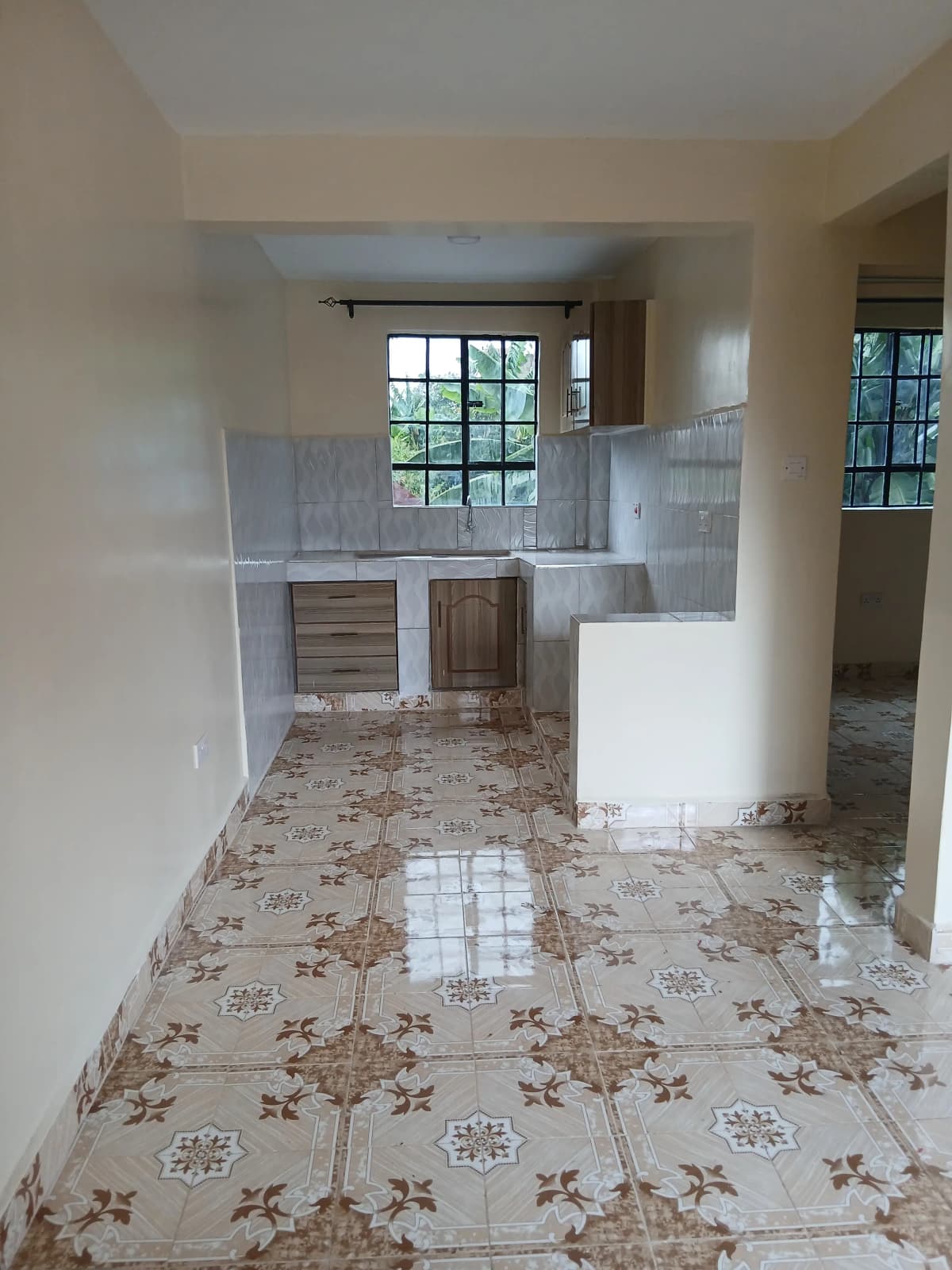 Open-plan living area with kitchen visible through doorway