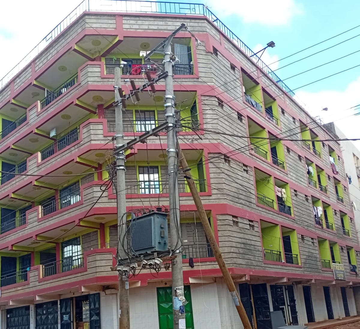 Pink and green multi-story residential building facade with balconies