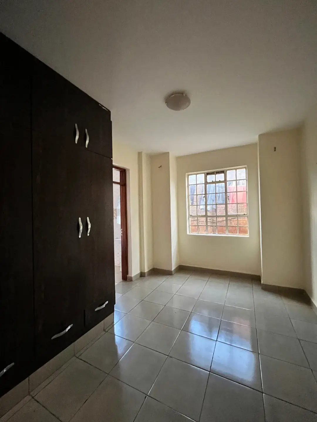 Spacious bedroom with built-in dark wardrobe and natural light