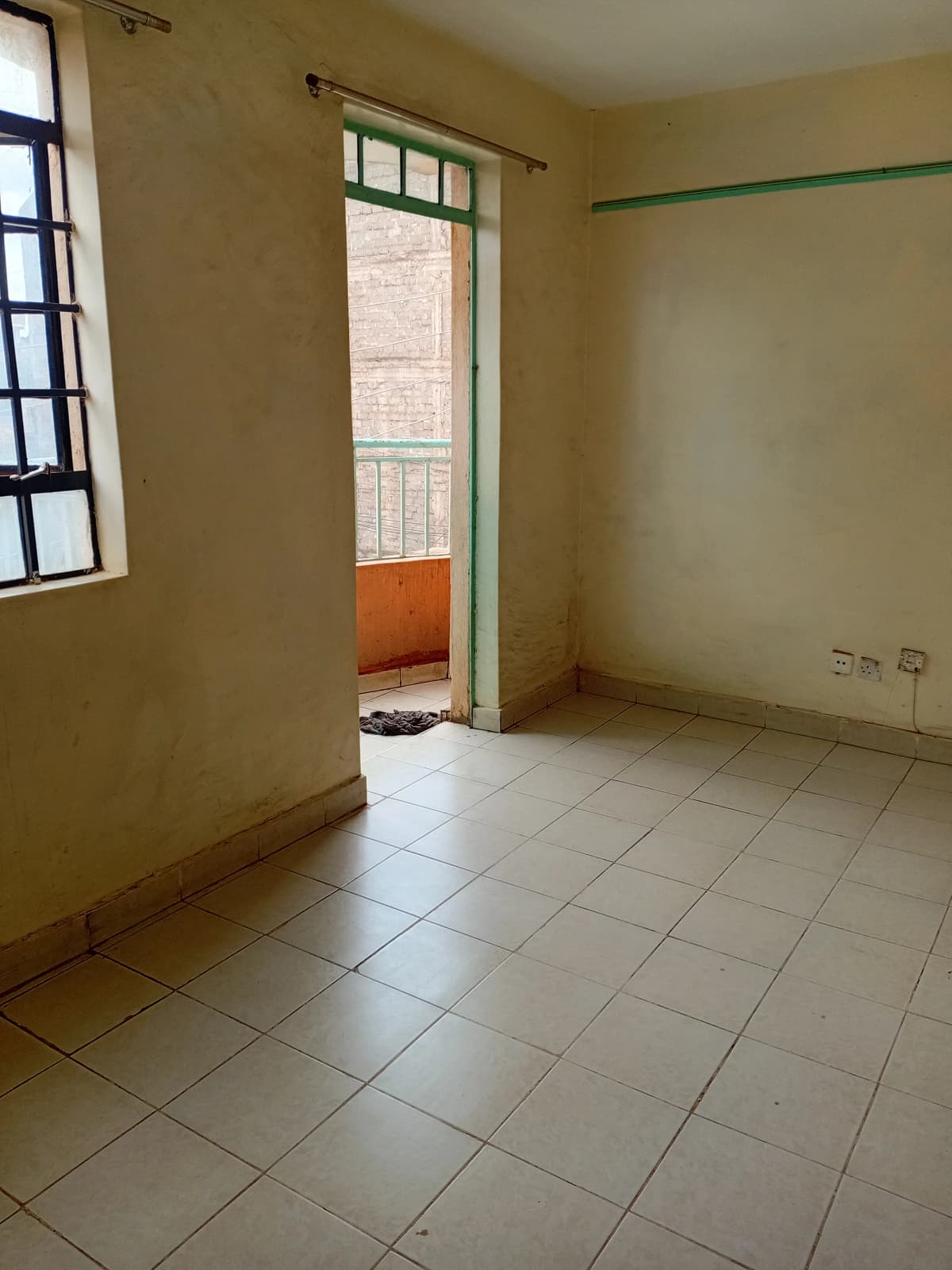 Unfurnished bedroom with tiled floor and balcony access