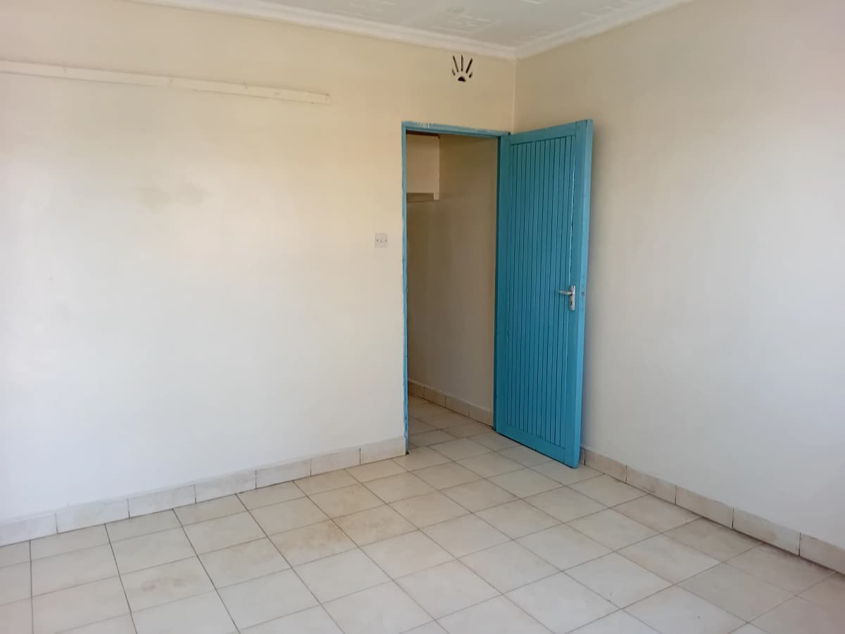 Empty bedroom with blue door and tiled floor