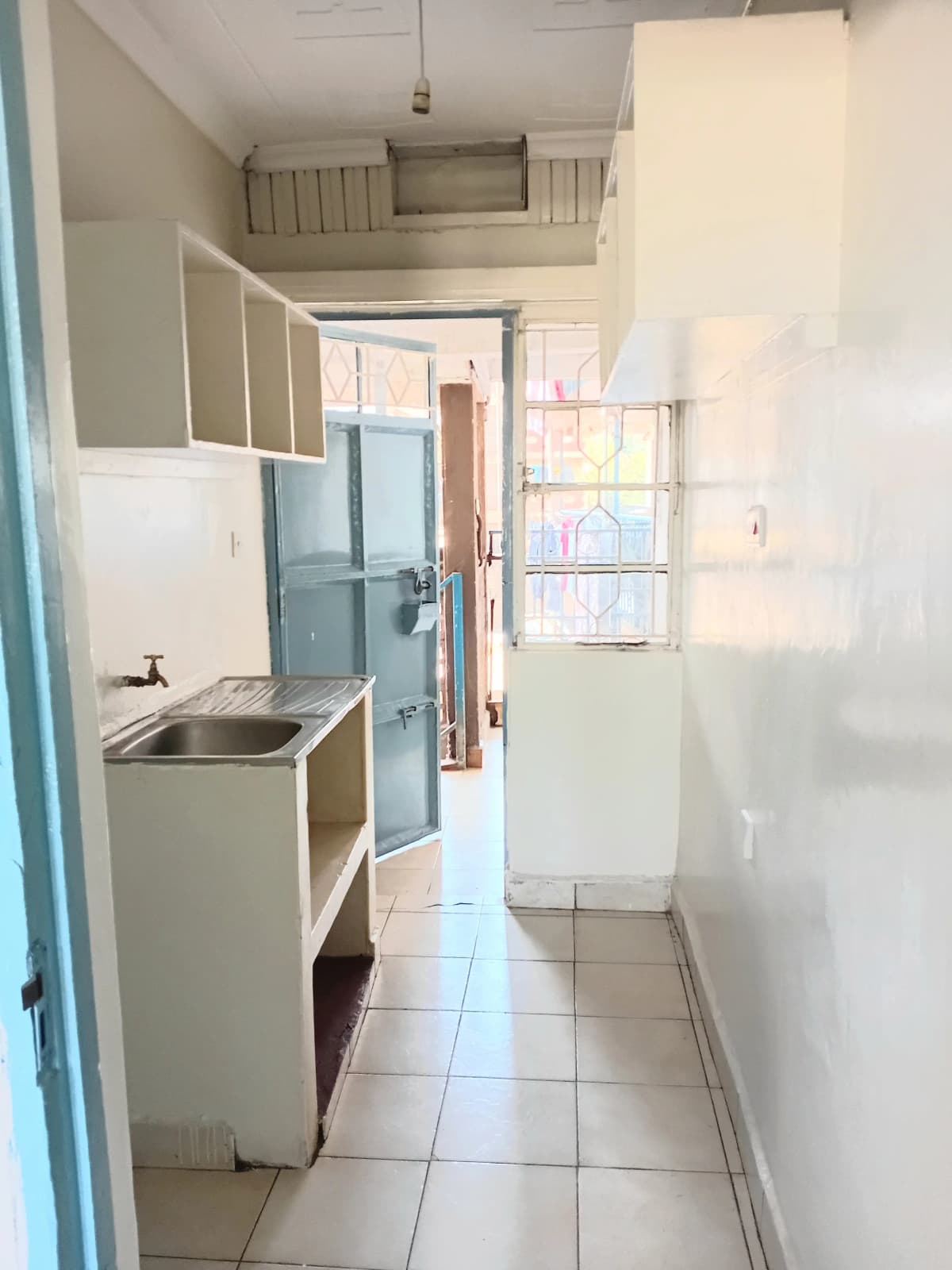 Compact galley kitchen with stainless steel sink and storage