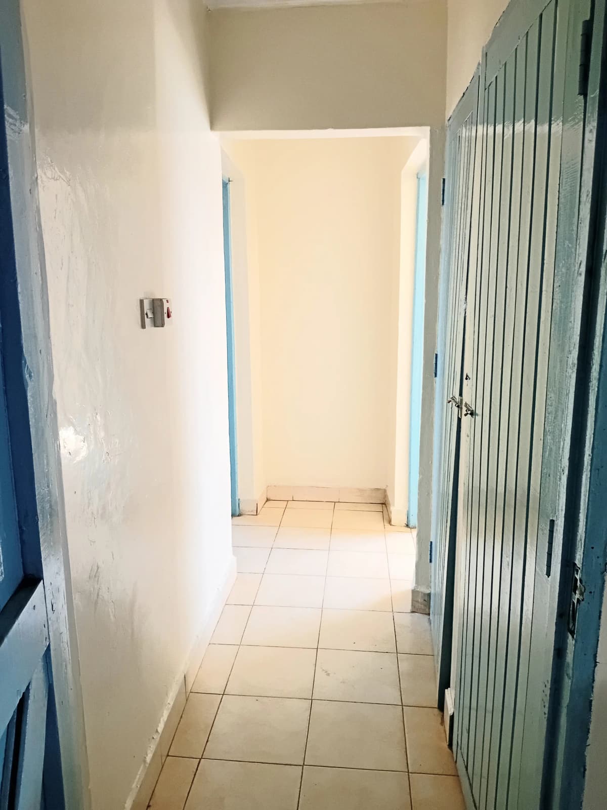 Narrow corridor with tile flooring and painted walls