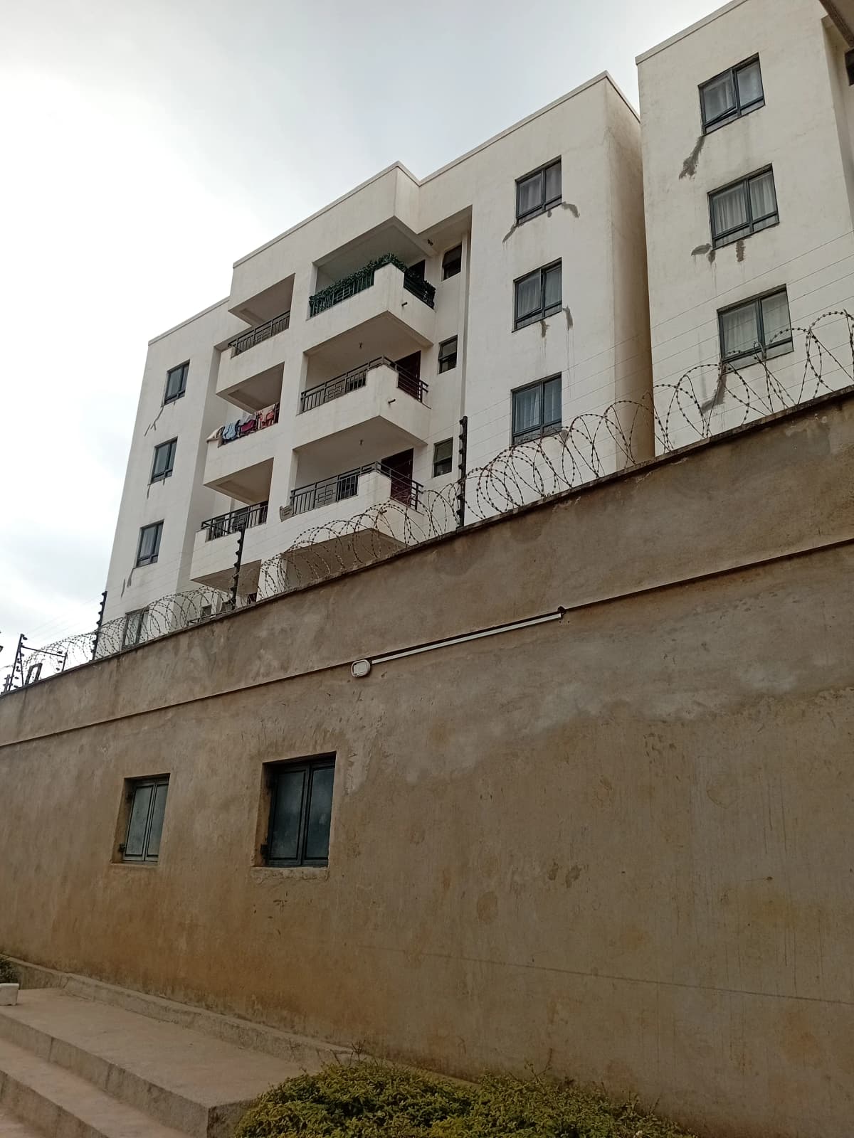 Multi-story residential building facade with balconies and perimeter wall