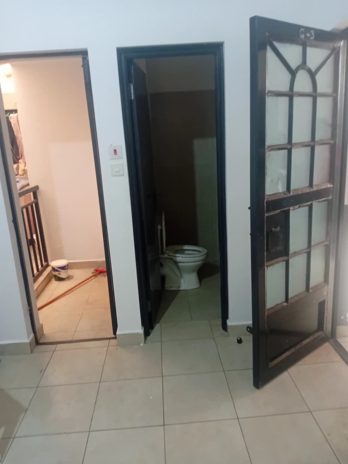 Toilet visible through open dark-framed bathroom door