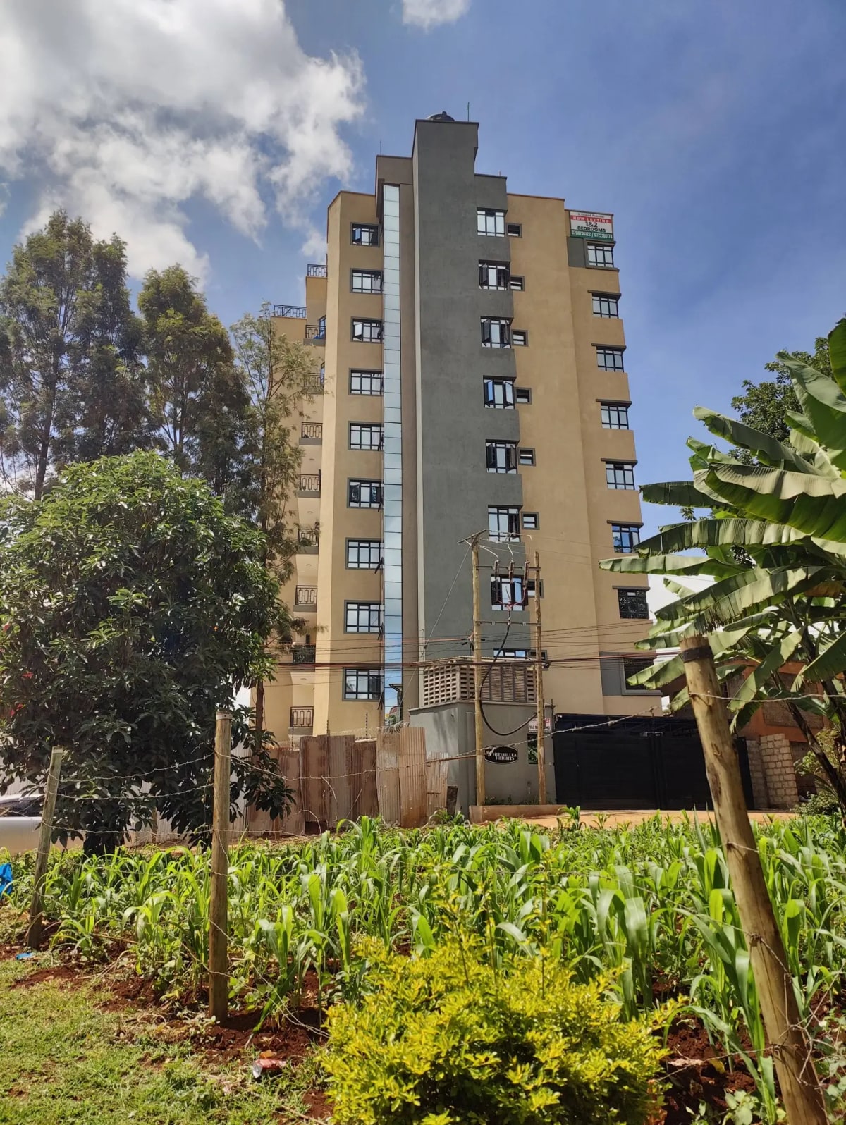 Multi-story residential building with landscaped garden grounds