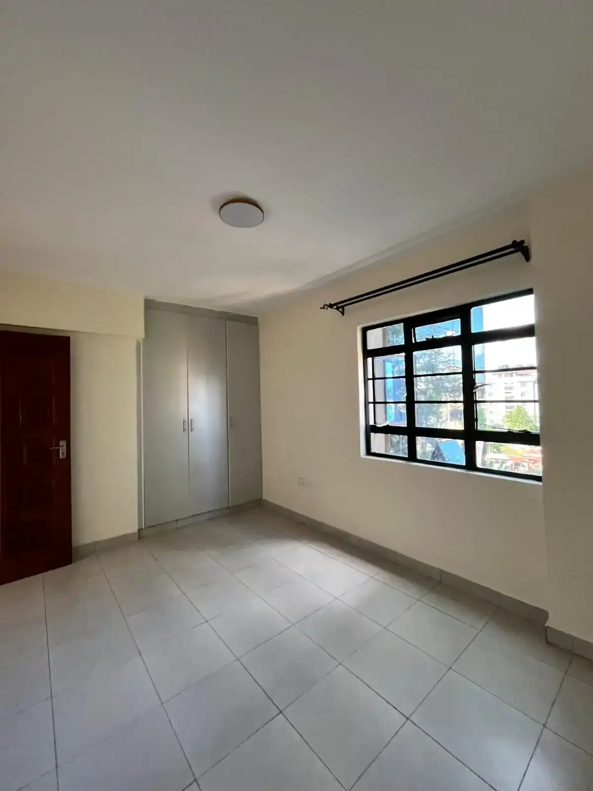 Bright bedroom with tile flooring and large window