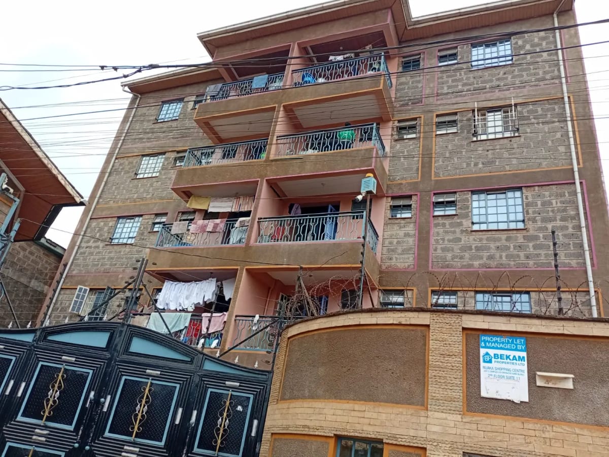 Multi-story residential building facade with balconies and gate