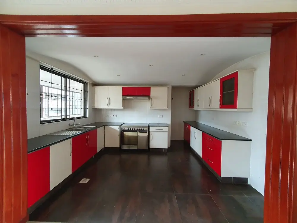 Modern kitchen with red and white cabinetry, dark flooring