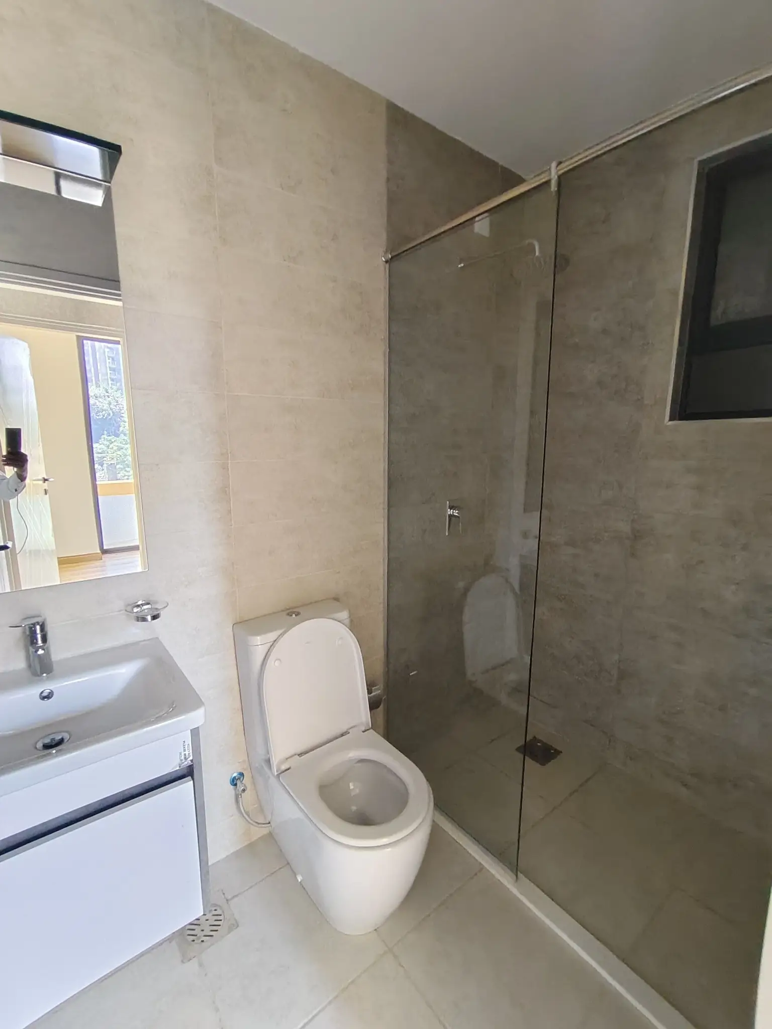 Modern bathroom with toilet, sink, and walk-in shower enclosure