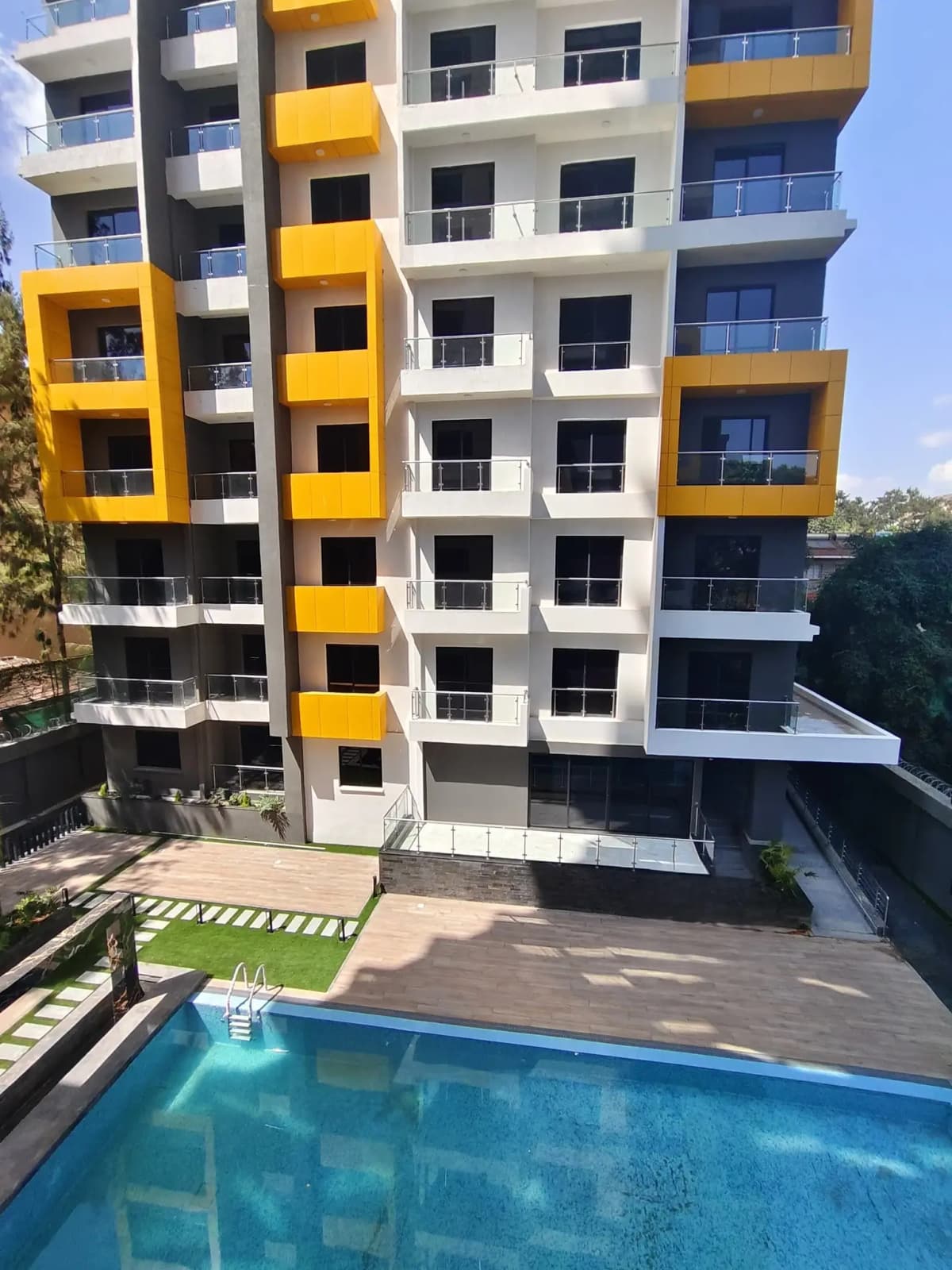 Resort-style swimming pool with modern apartment building backdrop