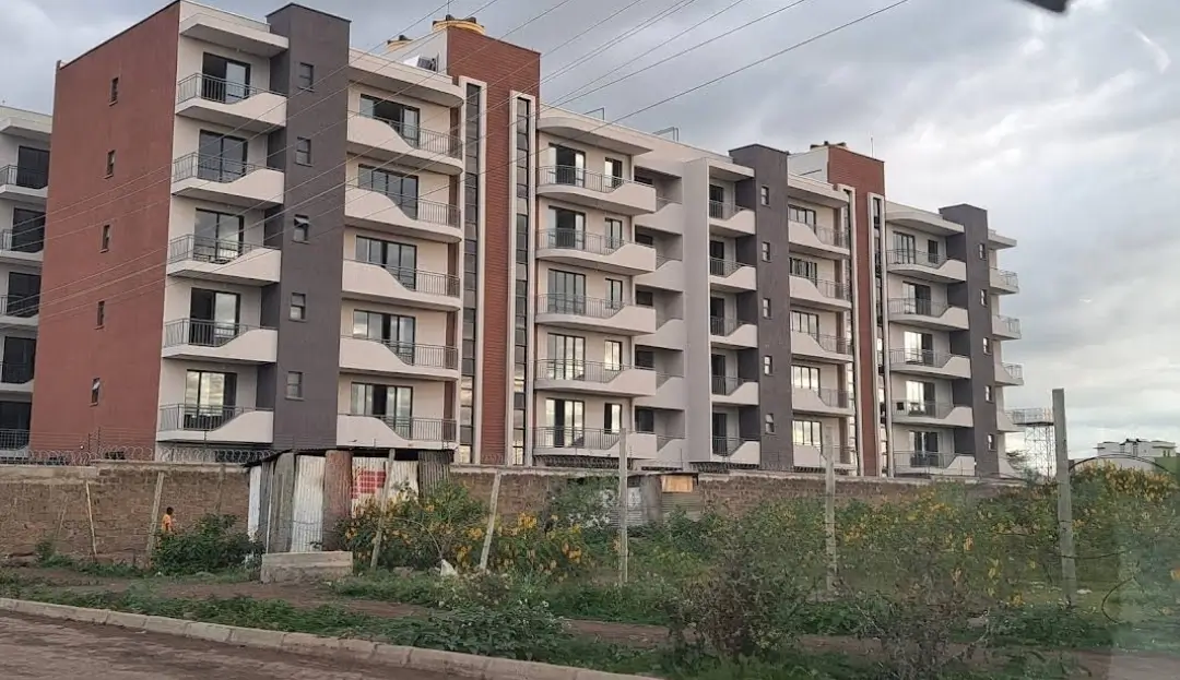 Multi-story residential apartment building with red and gray facade