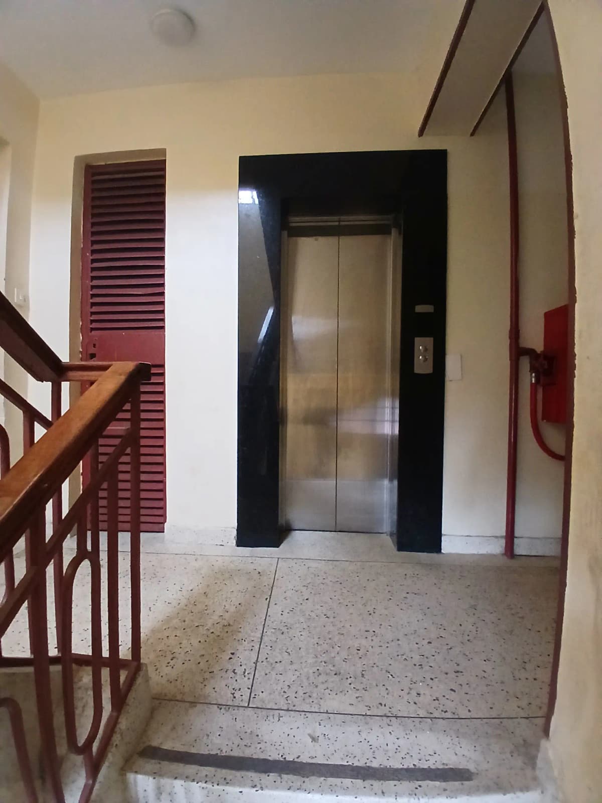 Building lobby with elevator, staircase, and fire extinguisher