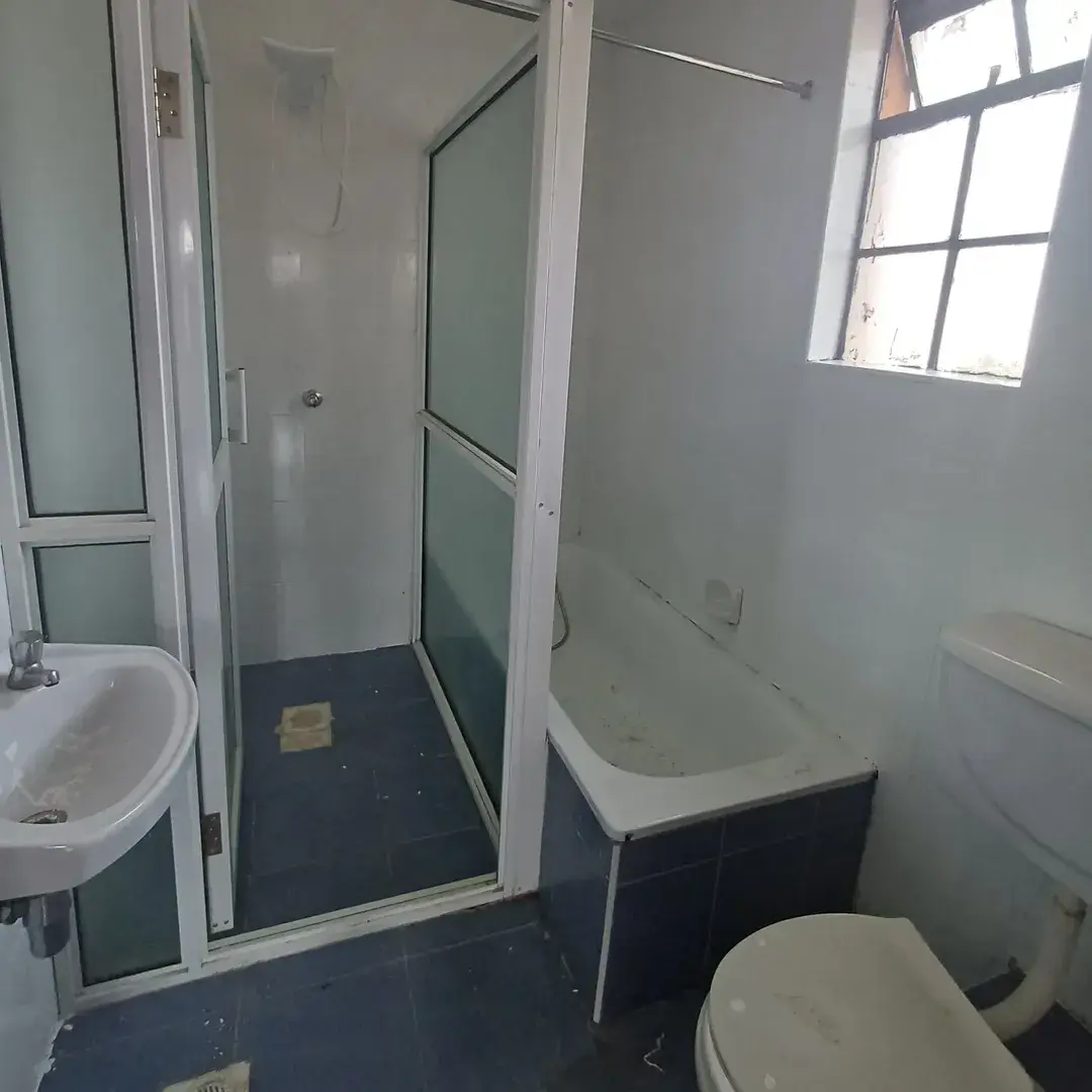 Compact bathroom with shower enclosure, toilet, and sink