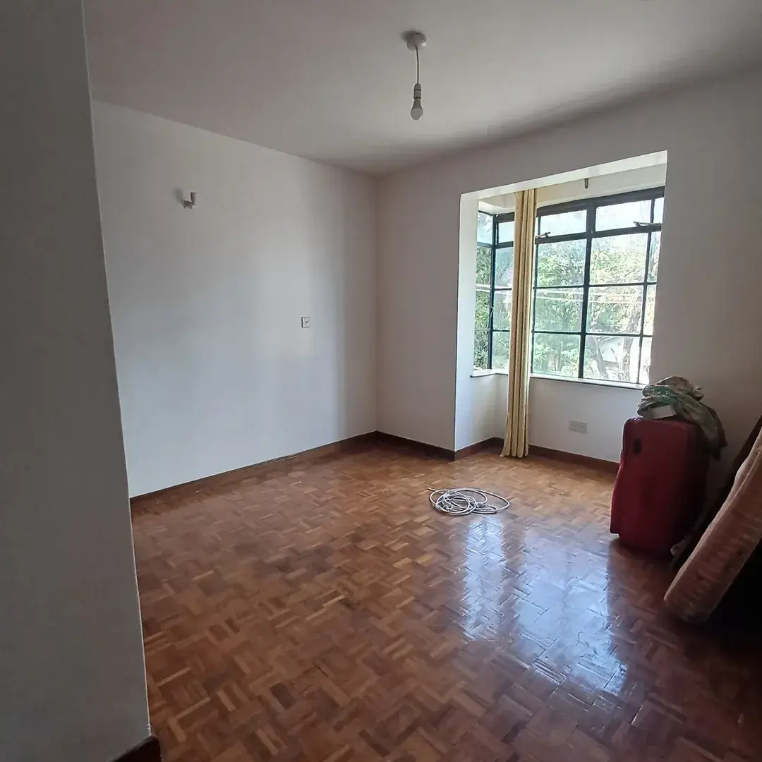 Spacious bedroom with herringbone flooring and large windows