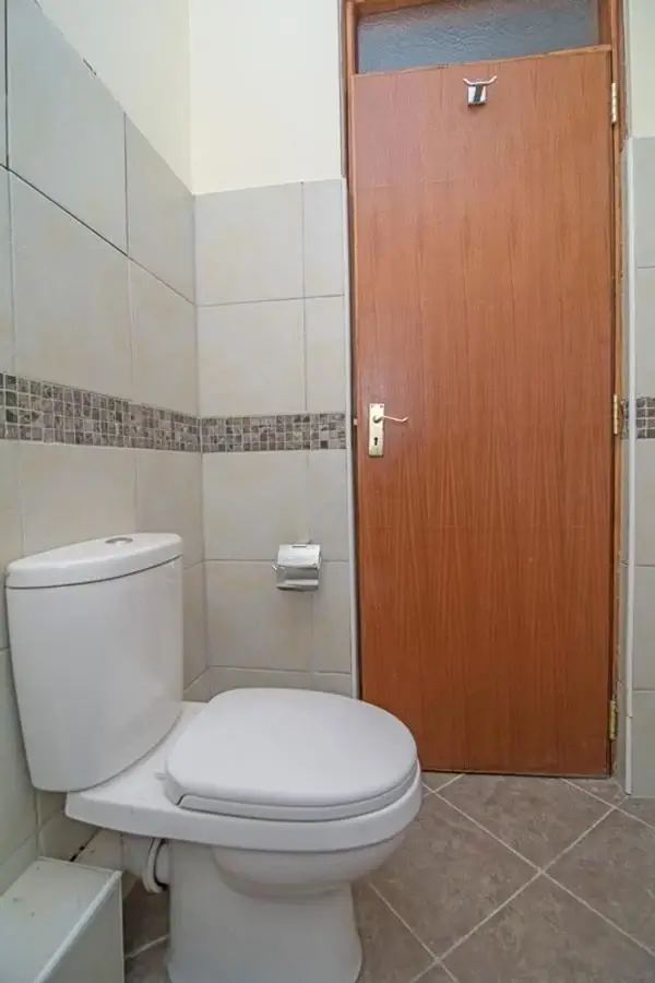 Compact bathroom with white toilet and decorative tile accents