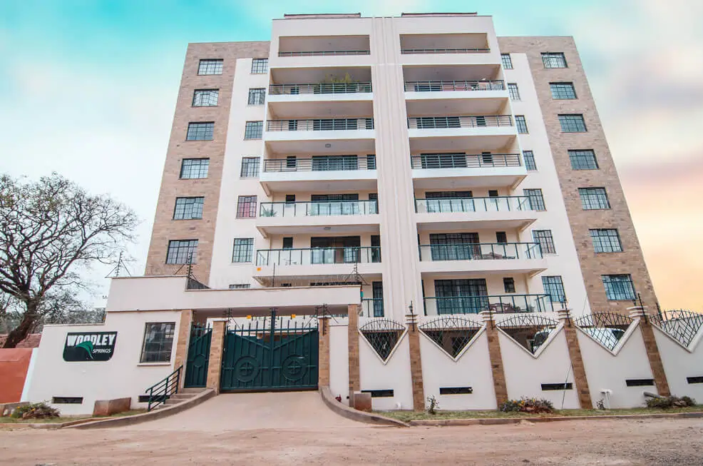 Modern multi-story residential building with secure gate entrance