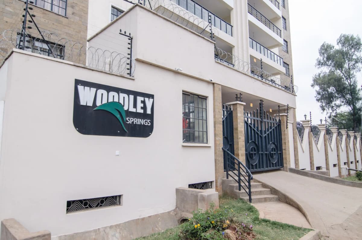 Building entrance with Woodley Springs signage and metal gate