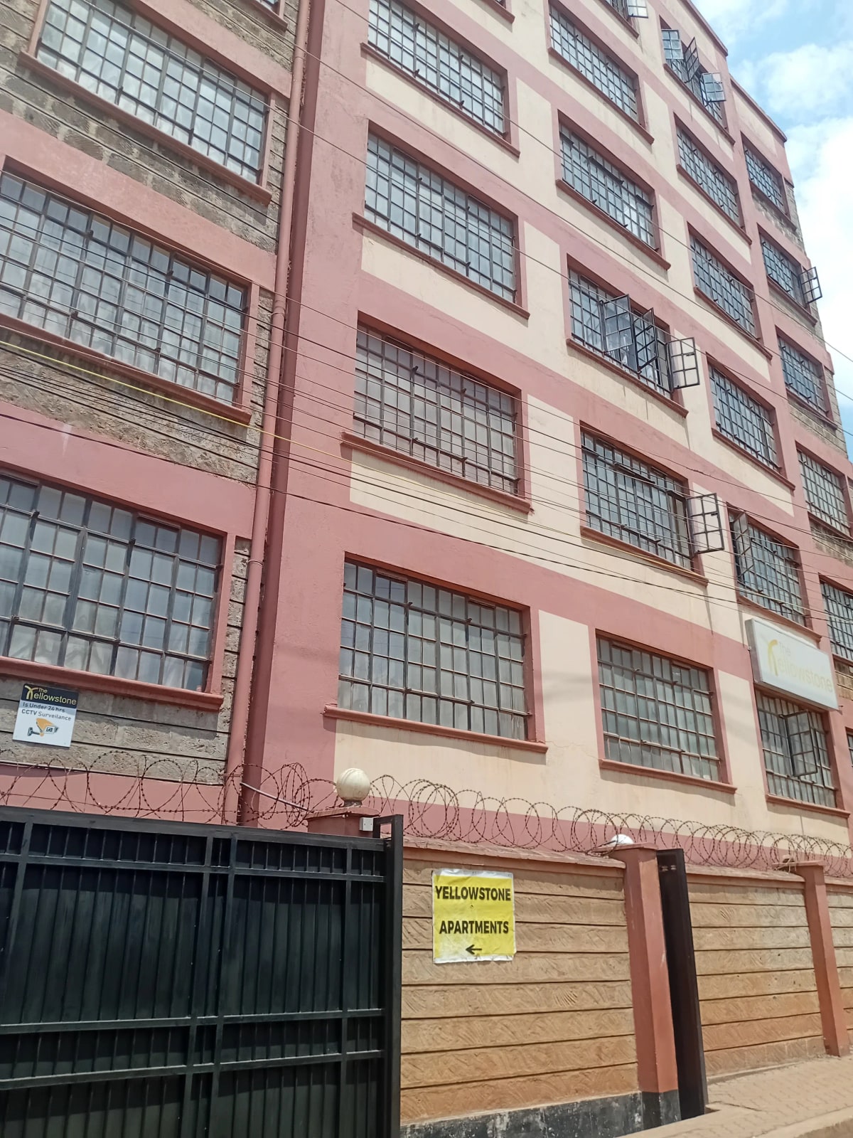 Multi-story residential building facade with metal-barred windows