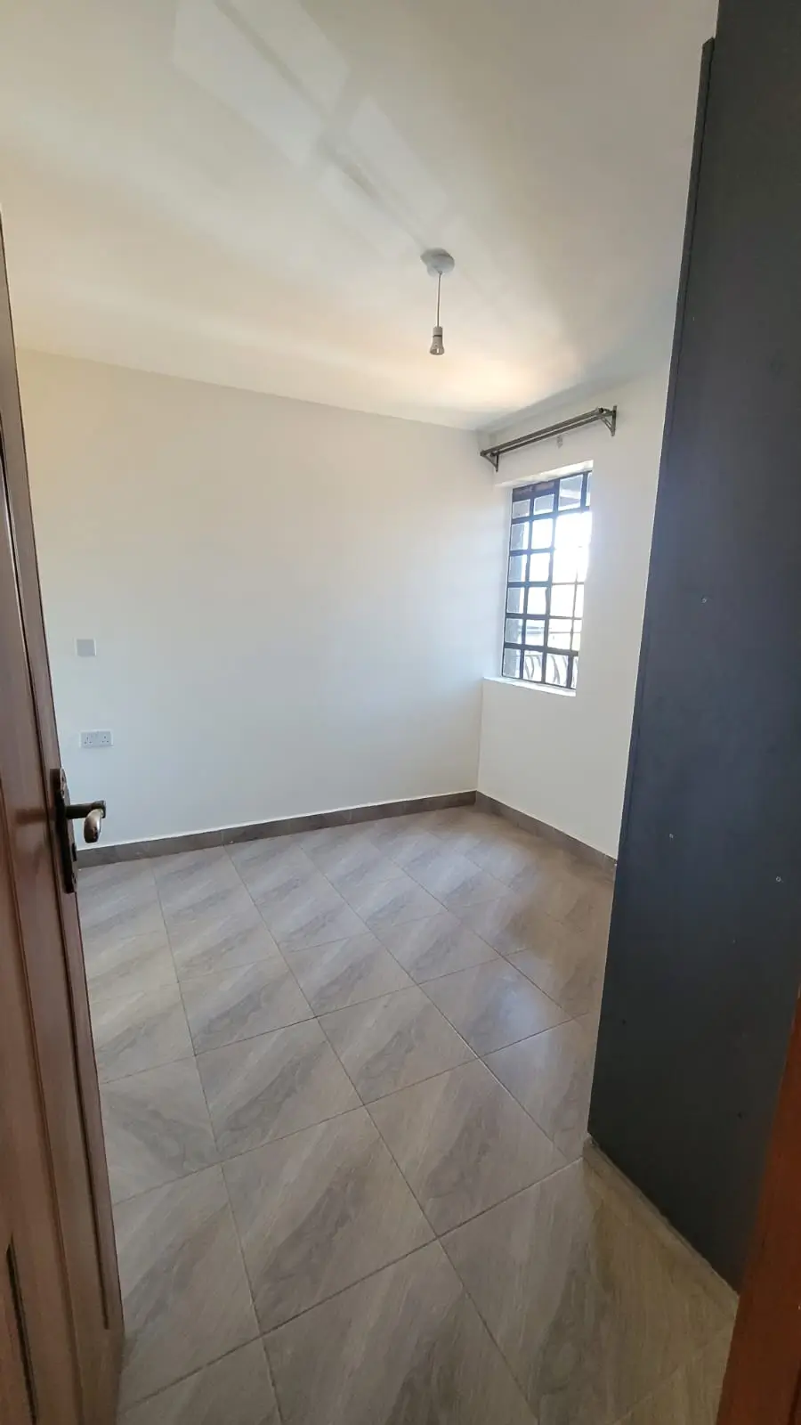 Bright empty bedroom with wooden flooring and natural light