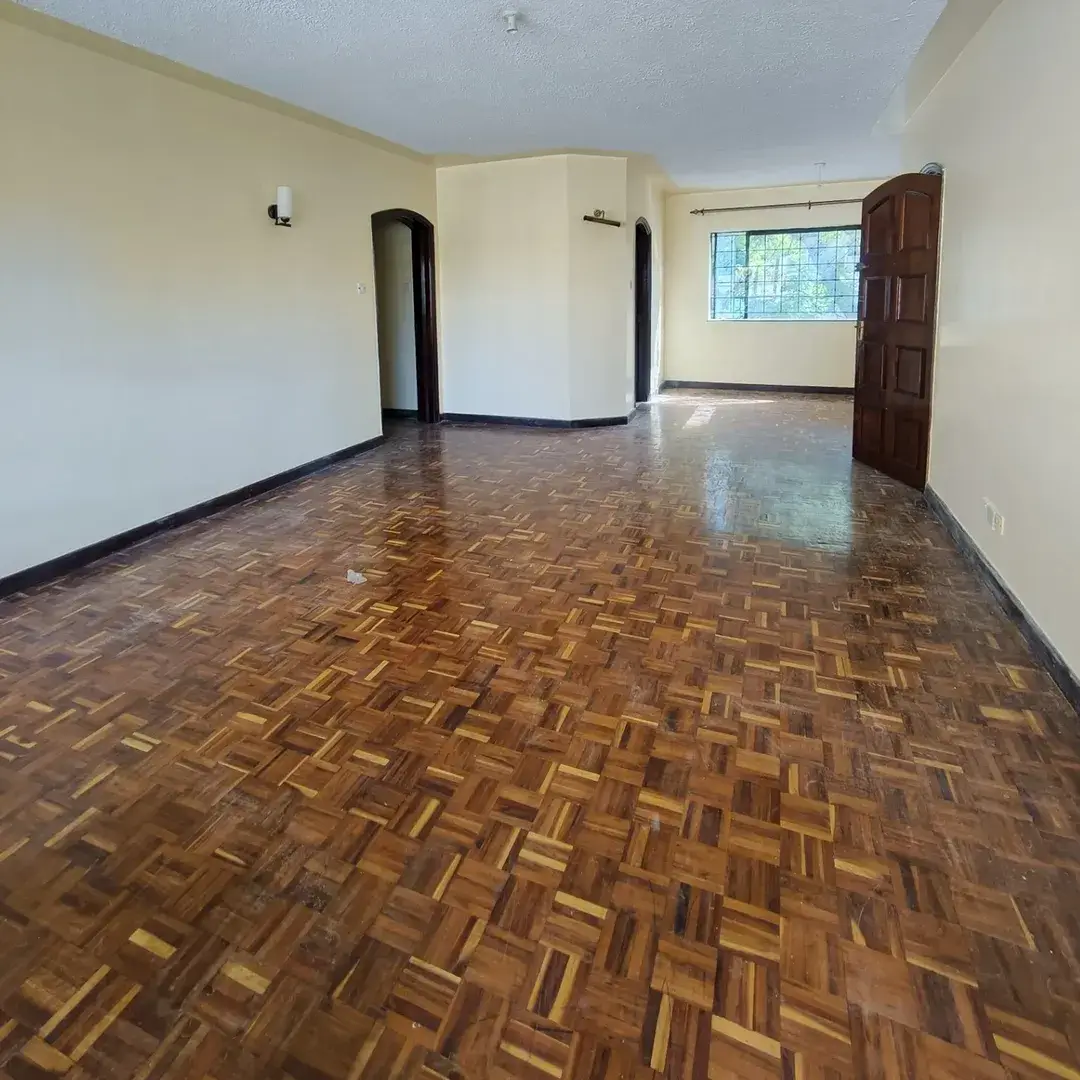 Spacious empty living room with parquet flooring and natural light