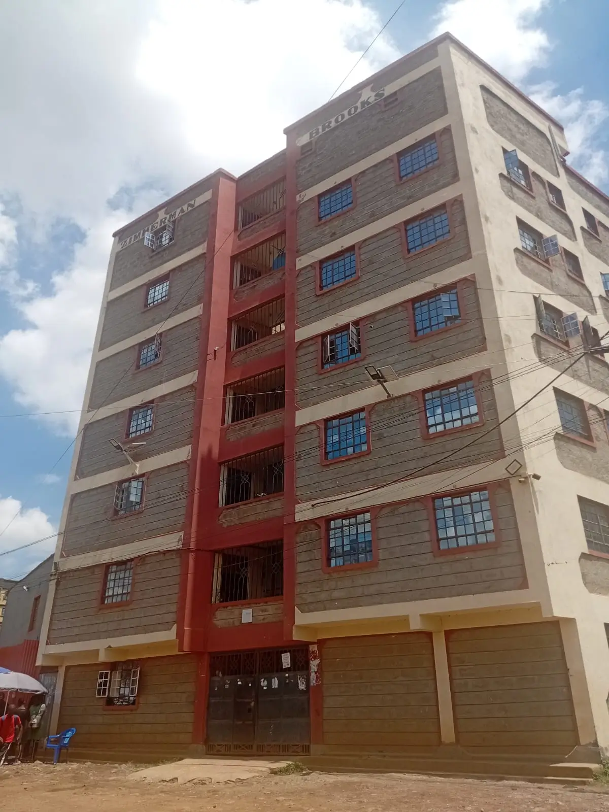 Multi-story residential apartment building facade with red accents