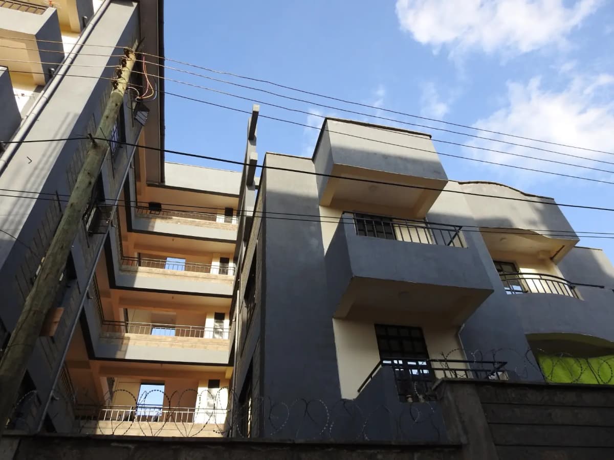 Multi-story residential building facade with balconies and power lines