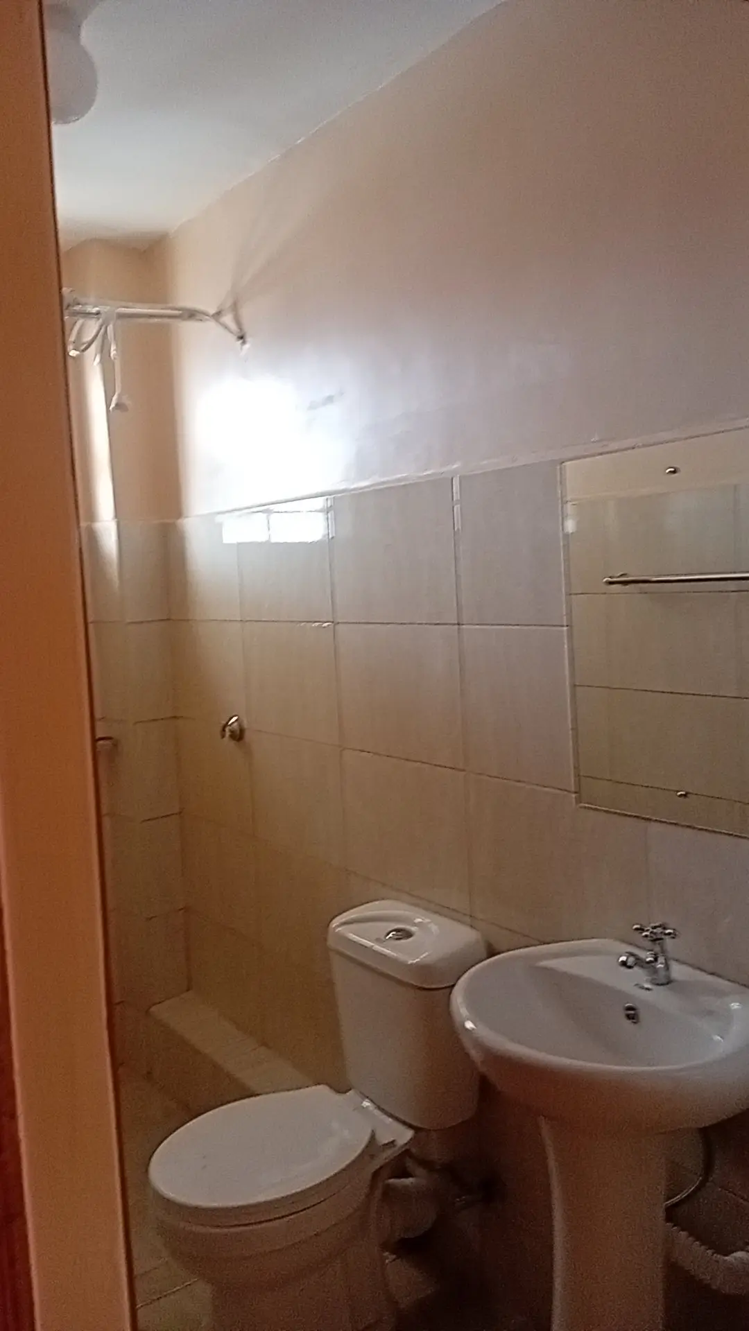 Small bathroom with toilet, sink, and shower cubicle