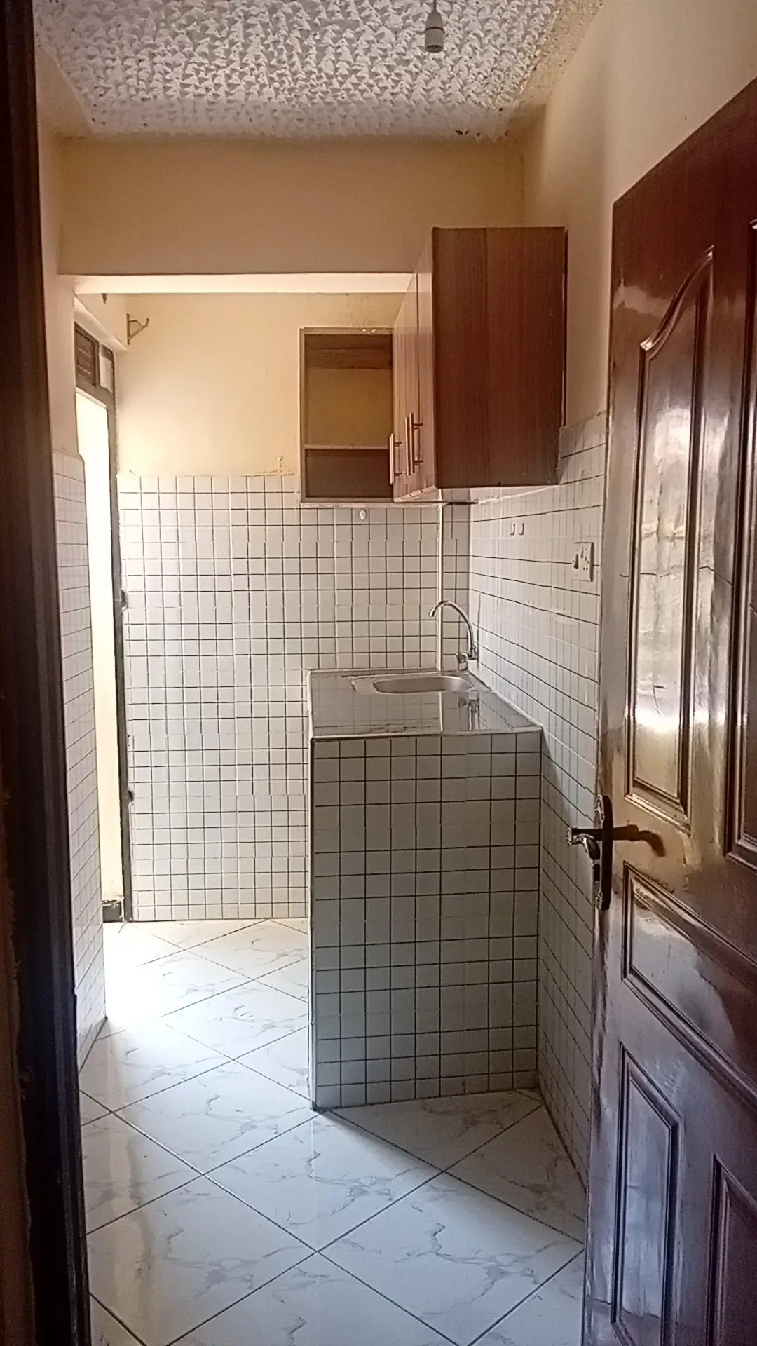 Bathroom with white tile walls, sink, and shower enclosure