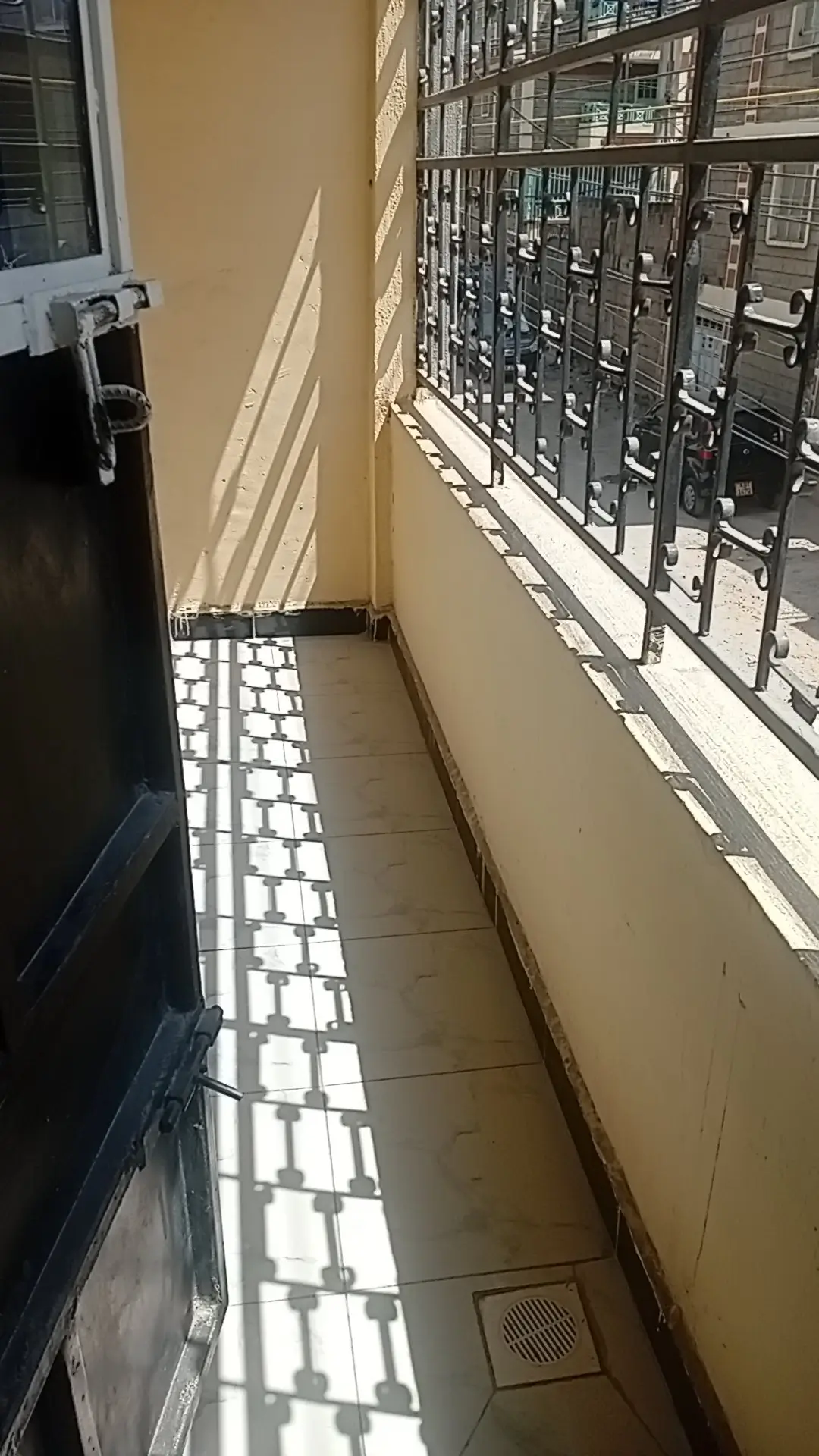 Narrow balcony with metal railing and tiled flooring