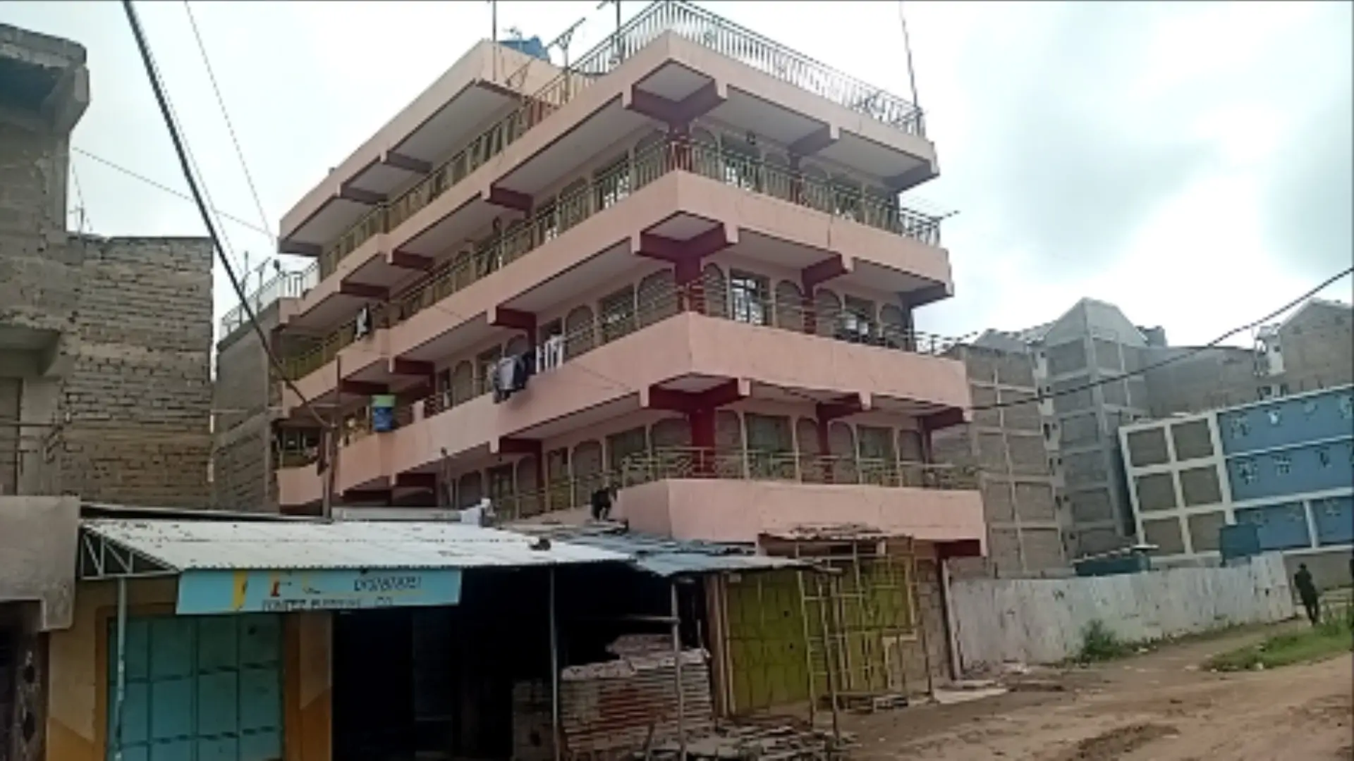 Multi-story residential building facade with balconies and ground-level shops