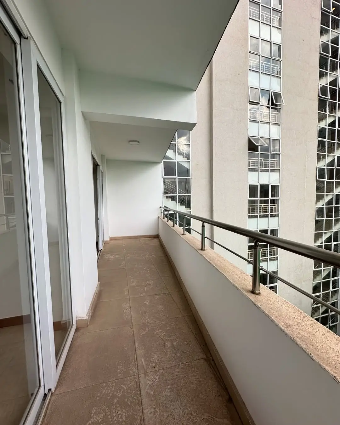 Long narrow balcony with metal railing and city views