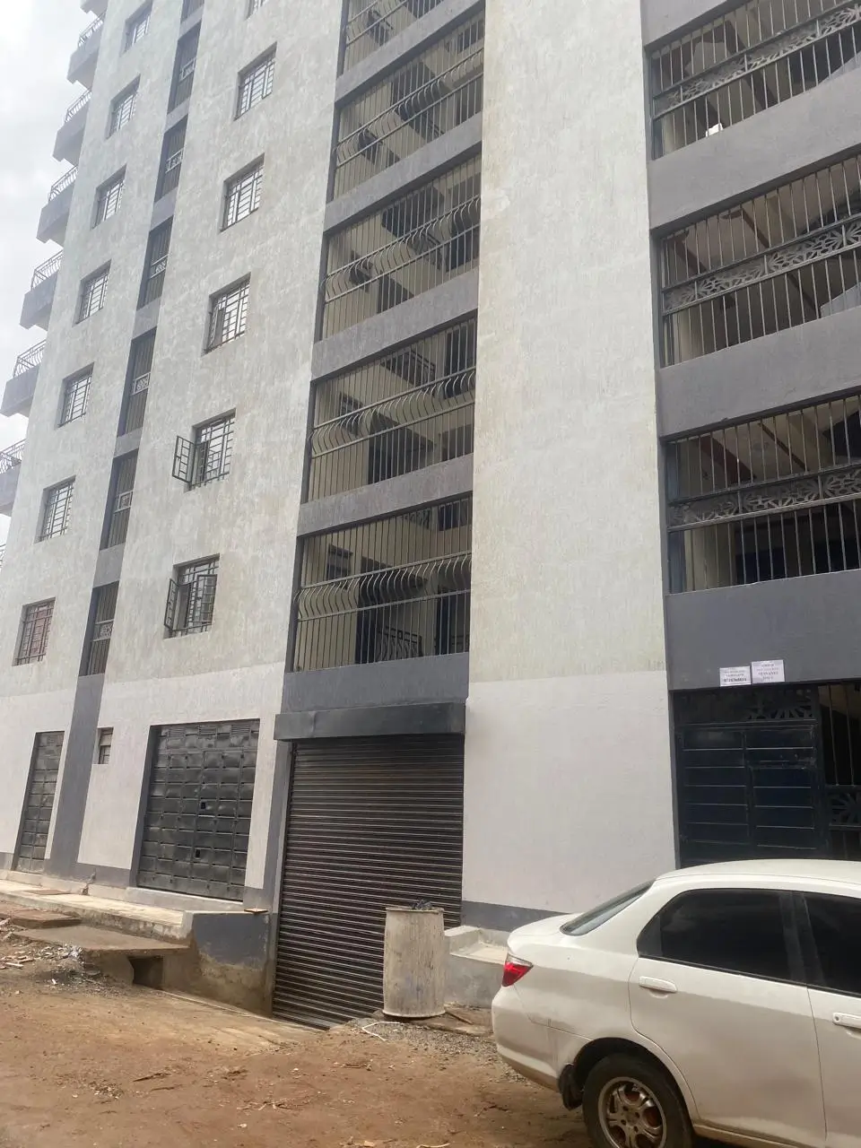 Modern apartment building facade with ground-level parking garage